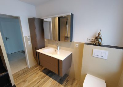 Bad mit fugenloser Wandverkleidung hinter Waschtisch und Wand-WC